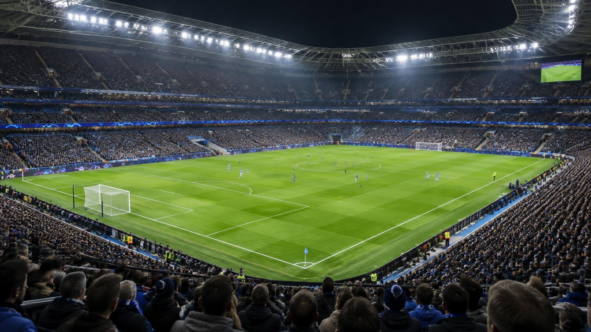 Football stadium filled with fans under floodlights